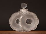 une bouteille en verre transparent ornée d'un motif floral