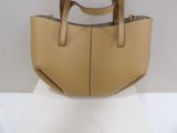 beige leather handbag on display on white surface with white background
