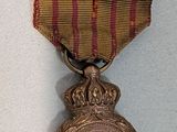 une médaille entourée d'un ruban, posée sur un fond blanc