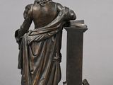 statue of a man sitting on a pedestal with a book
