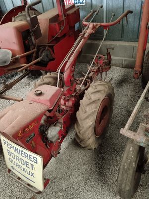a red tractor parked next to a trailer with a sign on it