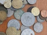 a pile of coins sitting on a wooden table