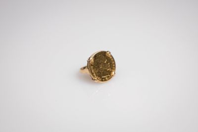 gros plan d'une bague en or sur une surface blanche