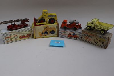 cinq camions miniatures et une boîte remplie de boîtes posées sur une table