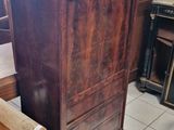 a wooden bench in the middle of a room next to a dresser