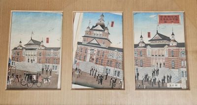 trois tableaux accrochés au mur d'un immeuble doté d'une tour horloge