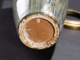 a close up of a vase with a ring on it