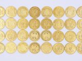 des pièces d'or sont disposées en rangées sur une surface blanche