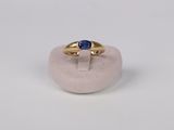 a close up of a gold ring with a blue stone