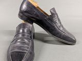 men ' s black loafer shoes with leather soles on a grey surface