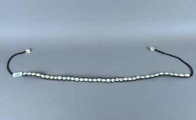 un bracelet en perles noires et blanches sur fond gris
