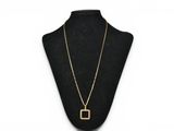 a gold necklace with a square pendant on a mannequin