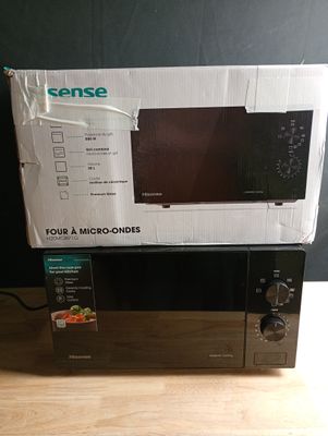 une boîte posée sur une table, avec un micro-ondes dessus