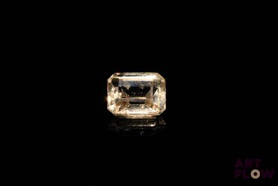 un diamant jaune sur une surface noire