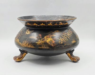 une image représentant un vase noir et doré orné d'oiseaux