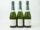 trois bouteilles de vin posées sur une table blanche