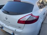 the back end of a white car parked in a parking lot