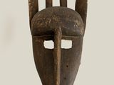 an old wooden mask with horns on it ' s face