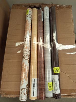 plusieurs rouleaux de papier d'emballage posés sur une boîte en carton