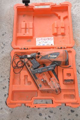 an orange tool box with a corded nail gun in it