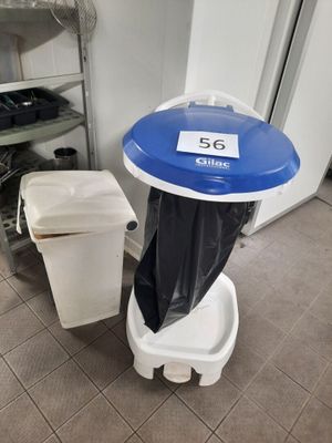 a trash can sitting next to a trash can in a bathroom