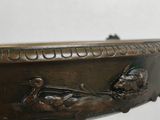 a bronze bowl on a stand with a bird on it