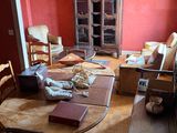 a room with a table, chairs, and a cabinet in it