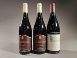 three bottles of wine are lined up on a table