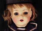 a close up of a doll with a hat on it ' s head