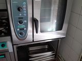 a silver oven sitting in a kitchen next to a stove