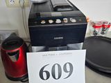 une cafetière posée sur un plan de travail, à côté d'un panneau