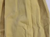 a yellow blanket on a bed with a white sheet