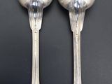 two spoons that are sitting next to each other on a table