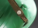 a close up of a green helmet with a brown strap