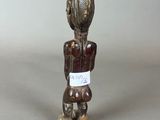 a small wooden figurine of a man with a hat on his head