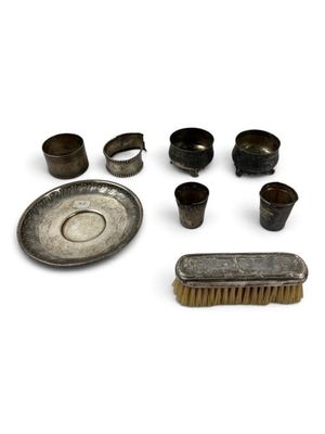 an assortment of metal objects including a brush, bowl, and other items