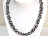 collier composé de perles de verre noires sur un mannequin blanc