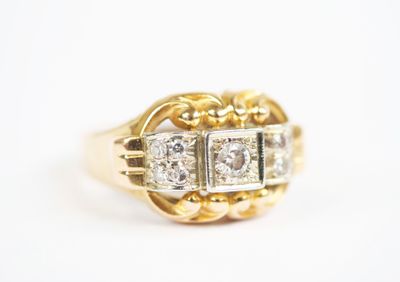 a close up of a gold and diamond ring on a white surface