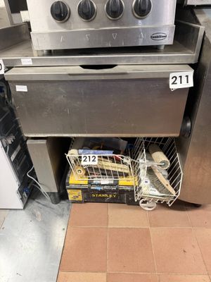 un poêle en argent devant lequel se trouve un panier rempli de nourriture
