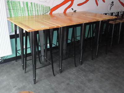 des tables et des tabourets dans une pièce où l'on voit une fresque murale