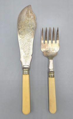 two forks and a knife are sitting next to each other