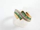 a close up of a gold ring with emeralds and diamonds