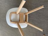 a white chair with wooden legs and a white seat