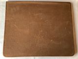 an image of a brown leather wallet sitting on top of a white sheet