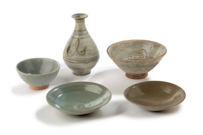 cinq bols et un vase posés sur une surface blanche