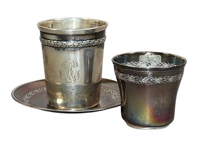 a silver cup and saucer sitting on a saucer