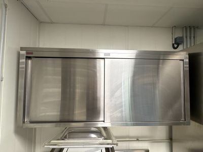 armoires en acier inoxydable dans une cuisine professionnelle équipée d'un évier et d'un lave-vaisselle