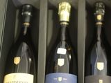Il y a trois bouteilles de vin dans une boîte posée sur une table