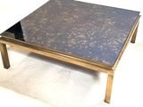 a black and gold coffee table with a glass top