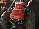 a red tractor that is sitting on a pallet